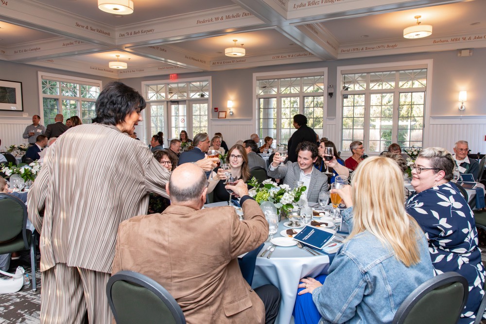 President Mantella raising a glass with a table